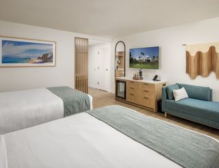Double queen room with blue and white coastal interior featuring wooden accents.