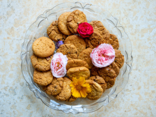 Glass plate of cookies decorated with flowers.